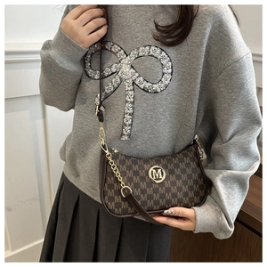 Detailed shot of dark brown vintage floral crossbody bag with gold chain strap