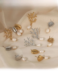 Detailed flat lay of ocean theme earrings set featuring coral and shell designs with pearls