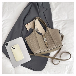 Flat lay of khaki monogram tote bag with brown PU leather trim and metal clasp detail