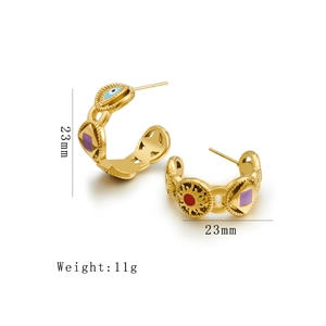 Detail of 23mm golden C-shaped hoop earrings with colorful enamel eye and sun patterns
