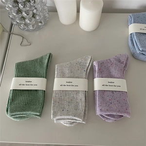 Detail of colorful flecked cotton socks in pastel tones with elegant paper packaging
