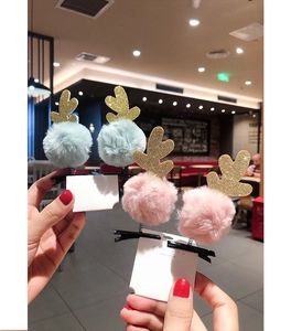 Detail of Christmas reindeer antler hair clips with glitter and fluffy pom poms