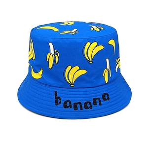 Detail of blue cotton bucket hat featuring yellow banana print and black embroidery