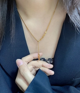Macro detail of 18K gold-plated vertical bar pendant on a minimalist chain necklace