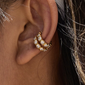 Close-up of 18K gold plated stainless steel ear cuffs with white zircons on model ear