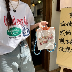 Détails de broderie sur mini sac en tissu Oxford avec motifs colorés et bandoulière tissée