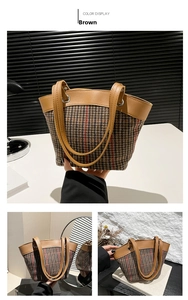 Detail of retro brown plaid canvas bucket bag with premium leather handles and metal hardware
