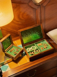 Detail of walnut wood jewelry box with green embossed glass lid and velvet lining