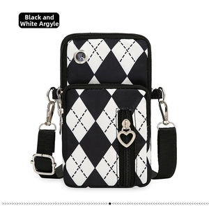 Detail of oxford fabric crossbody phone bag with black and white diamond pattern and heart zipper