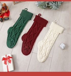 Three-piece chunky cable-knit Christmas stockings in green, burgundy, and ivory colors