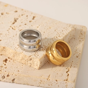 Minimalist wide double-layered 18K gold and silver stainless steel rings on stone base