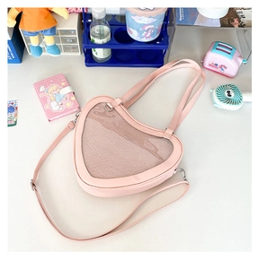 Detail of pink heart-shaped Ita bag with a transparent window for displaying badges