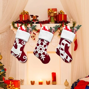Set of 3 embroidered velvet Christmas stockings hanging on a fireplace mantel