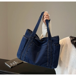 Close-up of deep blue denim tote bag texture with symmetrical side pockets and stitching