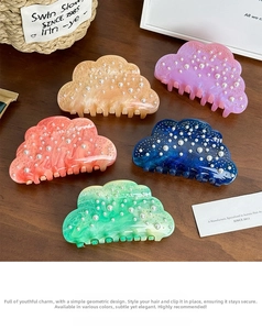 Detail of five-color acetate cloud hair claws with pearl embellishments on wood