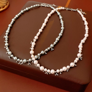 Detailed macro view of gray and pink pearl necklaces with star-shaped zircon pendants