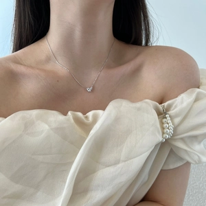 Close-up of S925 sterling silver necklace with heart shaped cubic zirconia on a female model