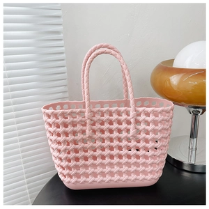 Detailed close-up of a pink woven hollow jelly beach basket with stylish handle texture