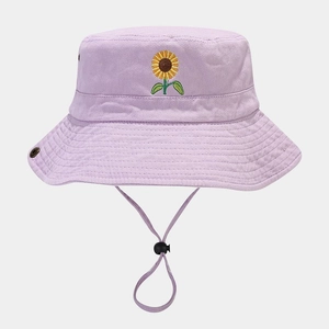 Detailed embroidery of a bright yellow sunflower on a lilac cotton fisherman bucket hat