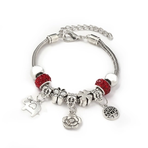 Detail of silver alloy bracelet with red rhinestones and elephant butterfly charms