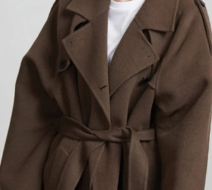 Détails du col d'un manteau en laine marron foncé avec fermeture à boutons et ceinture