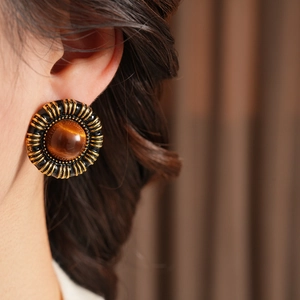 Close-up of vintage resin heart earrings featuring golden metal engraving and brown stone