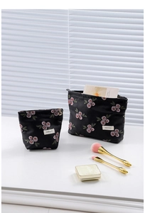 Close-up of vintage black jacquard makeup bags with red berry floral embroidery