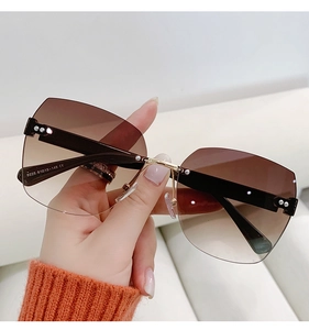 Detailed close-up of rimless gradient brown sunglasses with gold metal bridge and nose pads