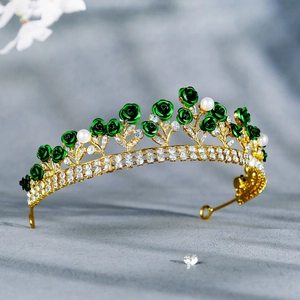 Detail of bridal crown with green enamel roses and white pearls on golden base