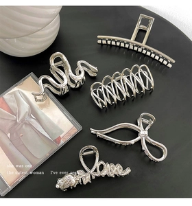 Detailed view of five assorted silver metal hair claws with sleek metallic finish