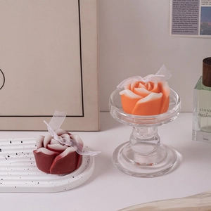 Rose shaped scented candles in orange and burgundy with delicate white mesh bow ties
