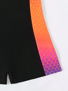 Detail of high-stretch black swimsuit with gradient mermaid scales pattern on side