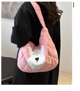 Detail view of pink quilted tote bag featuring a white plush puppy patch on padded fabric