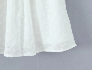 Detail of white cotton fabric with exquisite floral embroidery and hollow-out craft work