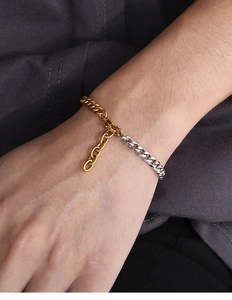 Detail of two-tone gold and silver Miami Cuban link bracelet with extension chain