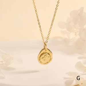 Close-up of gold coin pendant necklace featuring an embossed eagle and bird relief design
