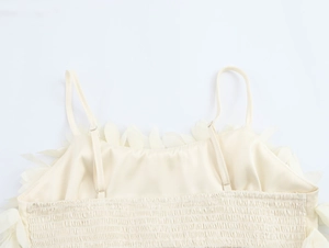 Detail of cream-white camisole back featuring delicate 3D floral petals and elastic gathers