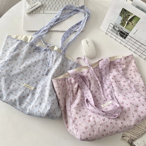 Flat lay of floral chiffon tote bags in light blue and purple with drawstring details