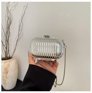Detail of silver metallic clutch with vertical pleated texture and long snake chain
