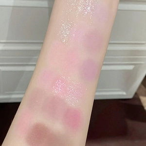 Arm swatches showing 18 colors of shimmering pink, purple and brown powder eyeshadow