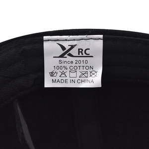 Detailed macro shot of the 100% cotton washing label inside the black baseball cap