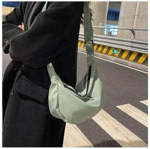 Side view of light green nylon crescent crossbody bag with adjustable wide strap for women