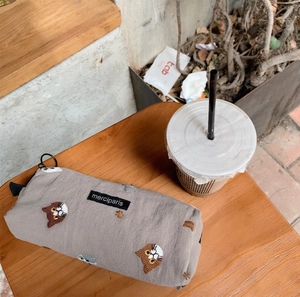 Detail of embroidered cats on a grey linen pencil case with black merciparis brand tag