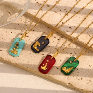 Detail of 18K gold plated necklaces featuring square acrylic charms with 3D snake emblems
