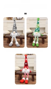 Close-up of lighted Christmas gnomes with knitted hats and striped legs for home decor