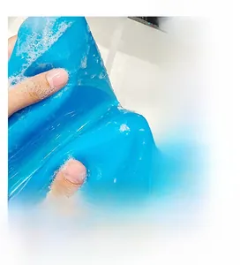 Close-up of flexible blue food-grade silicone kneading mat being washed under running water