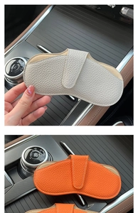 Detail of lychee pattern leather car sunglasses holders in grey and orange finishes