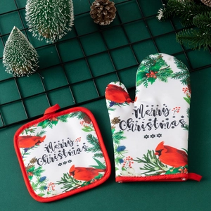 Close-up of festive Christmas oven mitt and pot holder set on a dark green background