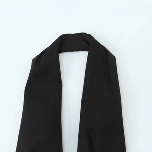 Flat lay view of a black halter neck top with belt accessory in smooth fabric texture
