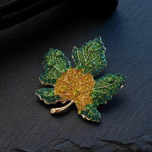 Macro detail of maple leaf brooch with gradient green and yellow rhinestones